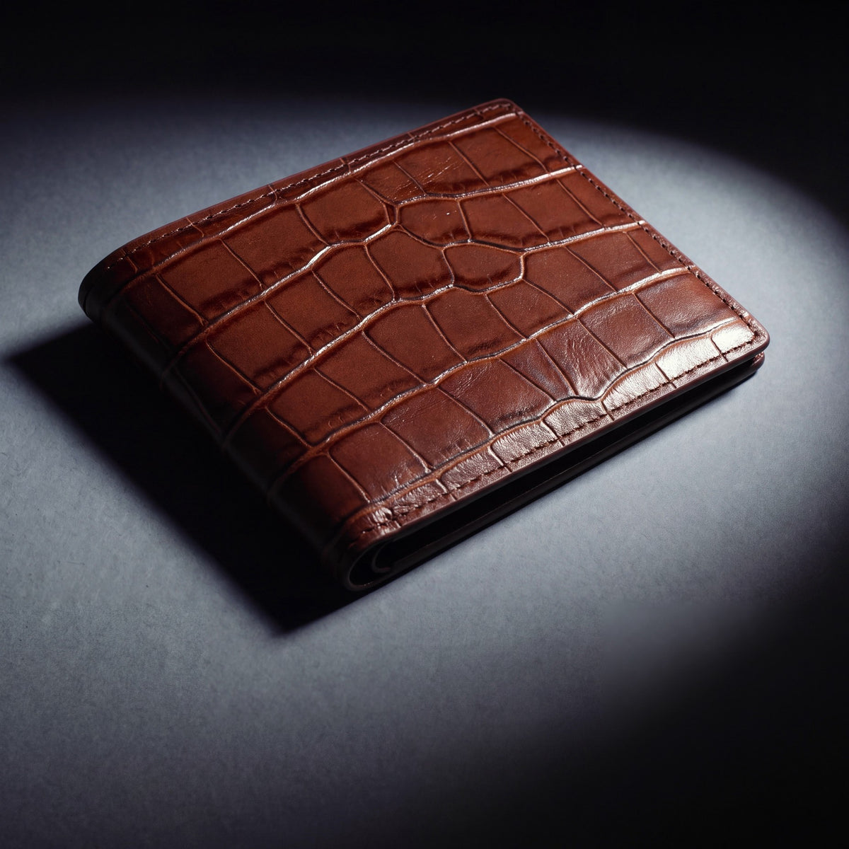 Close-up of the leather grain of a brown crocodile-embossed leather bifold wallet by GENTCREATE