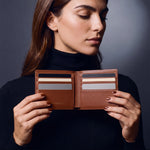 Woman opening a brown crocodile-embossed leather bifold wallet by GENTCREATE to show the card slots
