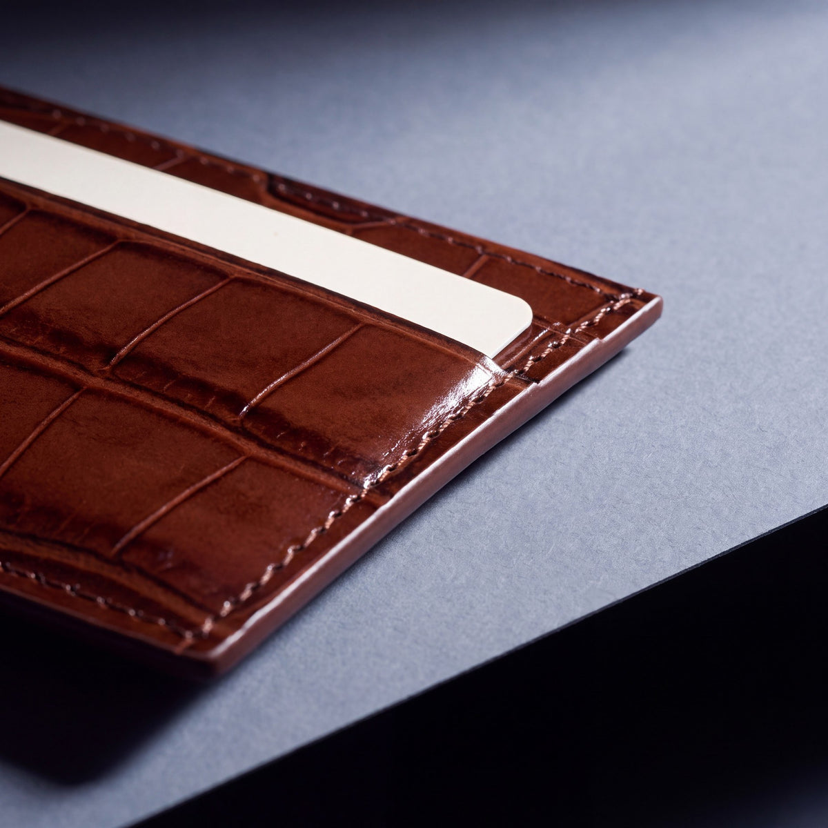 Close-up of the grain and edge of a brown crocodile-embossed leather card holder by GENTCREATE