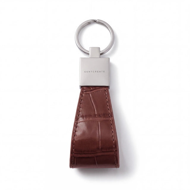 Brown crocodile-embossed leather keychain by GENTCREATE lying flat on white: split ring, polished clasp and stitched loop