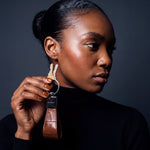 Woman holding up a brown crocodile-embossed leather keychain by GENTCREATE with house keys