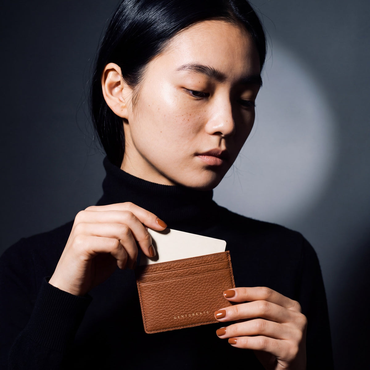 Woman sliding a card into a brown pebble leather card holder by GENTCREATE