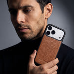 Man holding a brown pebble-grain leather iPhone 18 Pro Max case by GENTCREATE beside his face