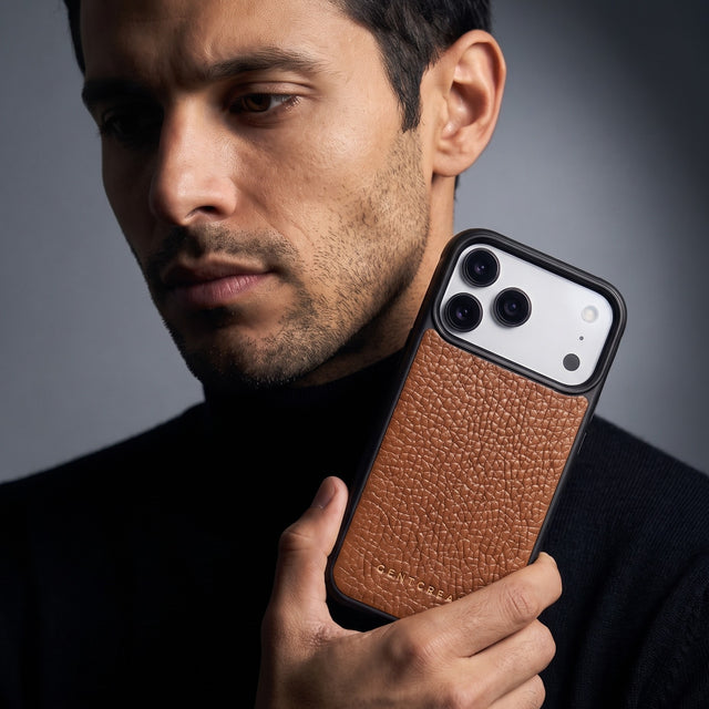 Man holding a brown pebble-grain leather iPhone 18 Pro Max case by GENTCREATE beside his face