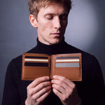 Man opening a brown Saffiano leather bifold wallet by GENTCREATE to show the card slots