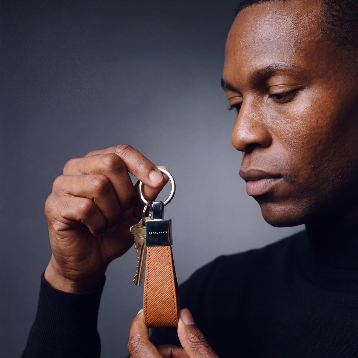 Man holding up a brown Saffiano leather keychain by GENTCREATE with house keys