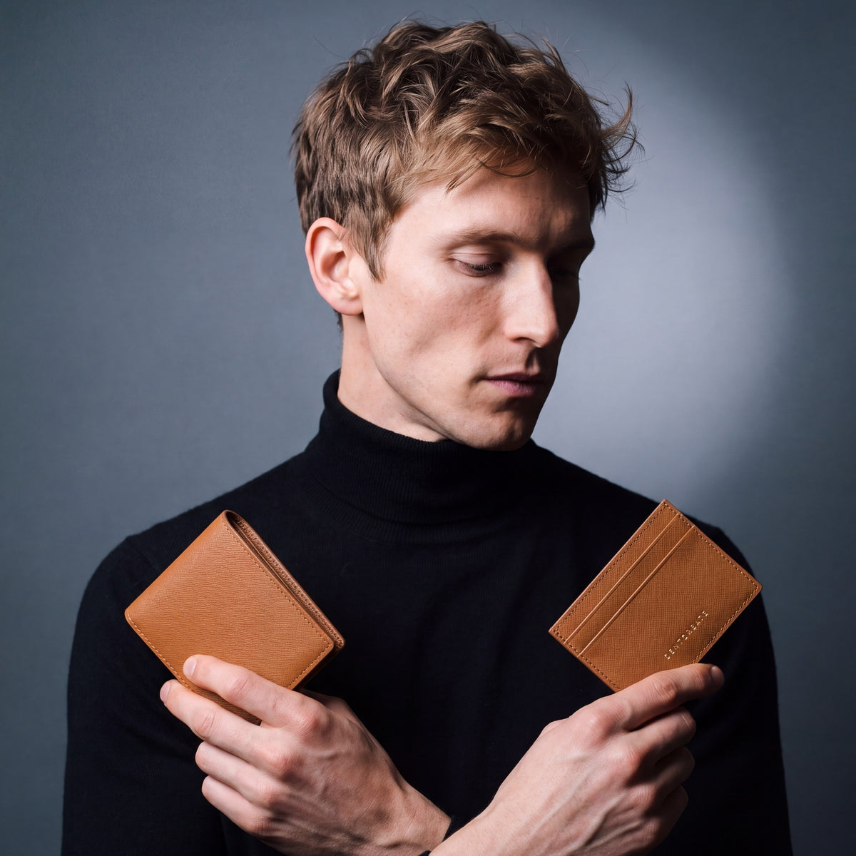 Man holding a matching brown Saffiano leather wallet and card holder set by GENTCREATE