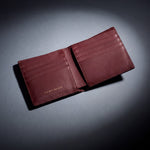 Burgundy crocodile-embossed leather bifold wallet by GENTCREATE lying open, studio still life