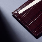 Close-up of the grain and edge of a burgundy crocodile-embossed leather card holder by GENTCREATE