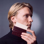 Man holding up a burgundy crocodile-embossed leather card holder by GENTCREATE with a card