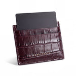 Burgundy crocodile-embossed leather card holder by GENTCREATE standing with a card, on white