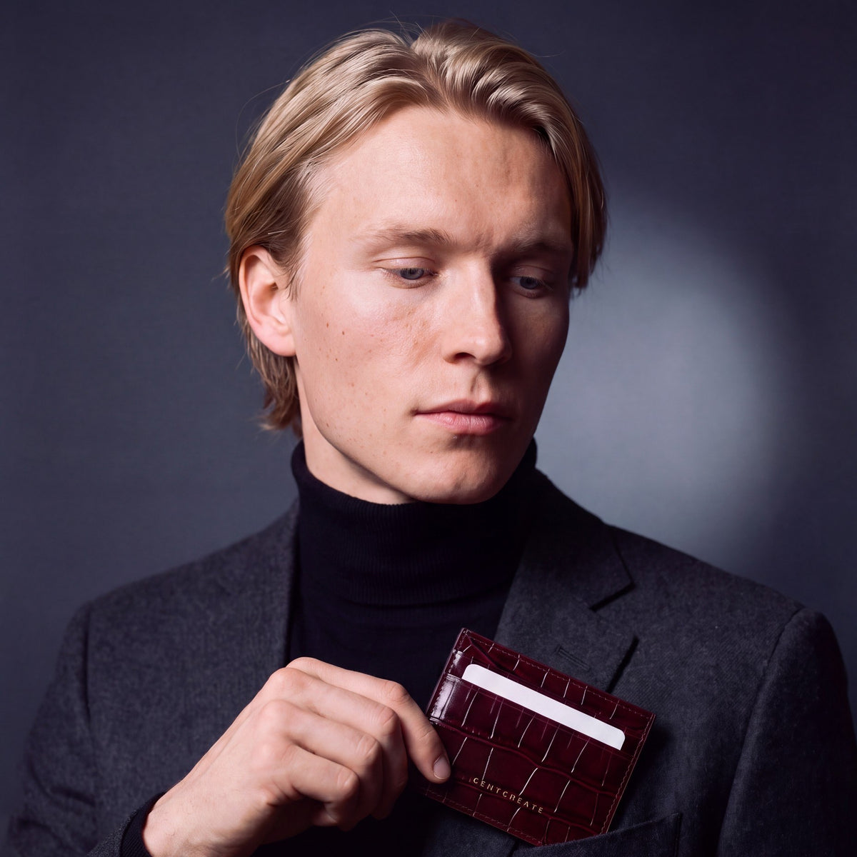 Man in a blazer taking a card from a burgundy crocodile-embossed leather card holder by GENTCREATE