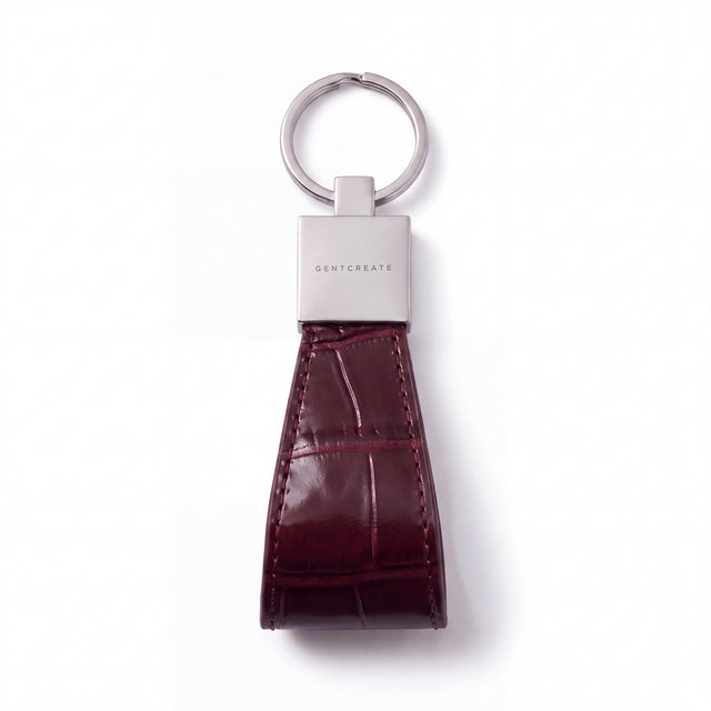 Burgundy crocodile-embossed leather keychain by GENTCREATE lying flat on white: split ring, polished clasp and stitched loop