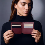 Woman opening a burgundy lizard-embossed leather bifold wallet by GENTCREATE to show the card slots