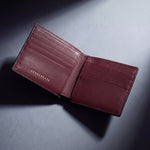 Burgundy lizard-embossed leather bifold wallet by GENTCREATE, studio still life