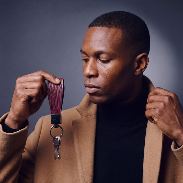 Man heading out with house keys on a burgundy lizard-embossed leather keychain by GENTCREATE