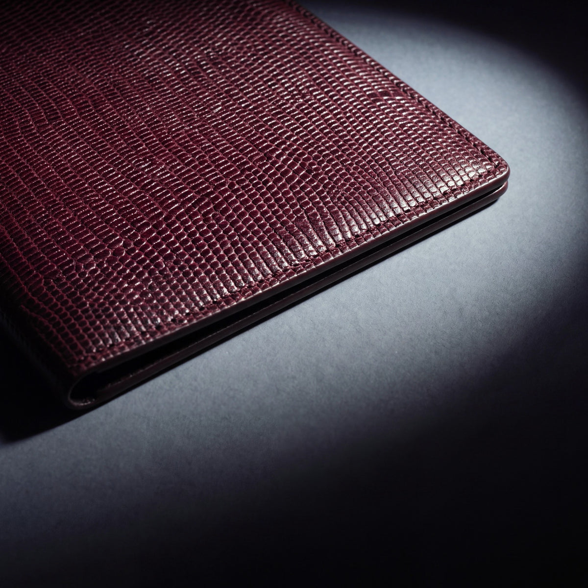 Close-up of the leather grain of a burgundy lizard-embossed leather passport holder by GENTCREATE
