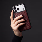 يد بأظافر حمراء داكنة تمسك جرابًا عنابيًا لهاتف iPhone 18 Pro Max من جلد عجل بنقش موجي بارز من GENTCREATE