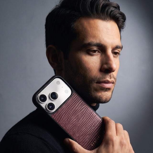 Man holding a burgundy wave-embossed leather iPhone 18 Pro Max case by GENTCREATE beside his face