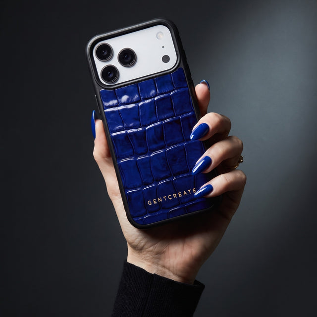 Hand with royal-blue nails holding a blue glossy crocodile-embossed calfskin iPhone 18 Pro Max case by GENTCREATE