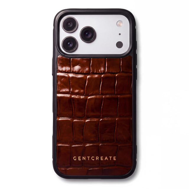 GENTCREATE का भूरा ग्लॉसी क्रोको-पैटर्न एम्बॉस्ड काफ़ लेदर iPhone 18 Pro केस, सफ़ेद बैकग्राउंड पर तिरछा रखा हुआ