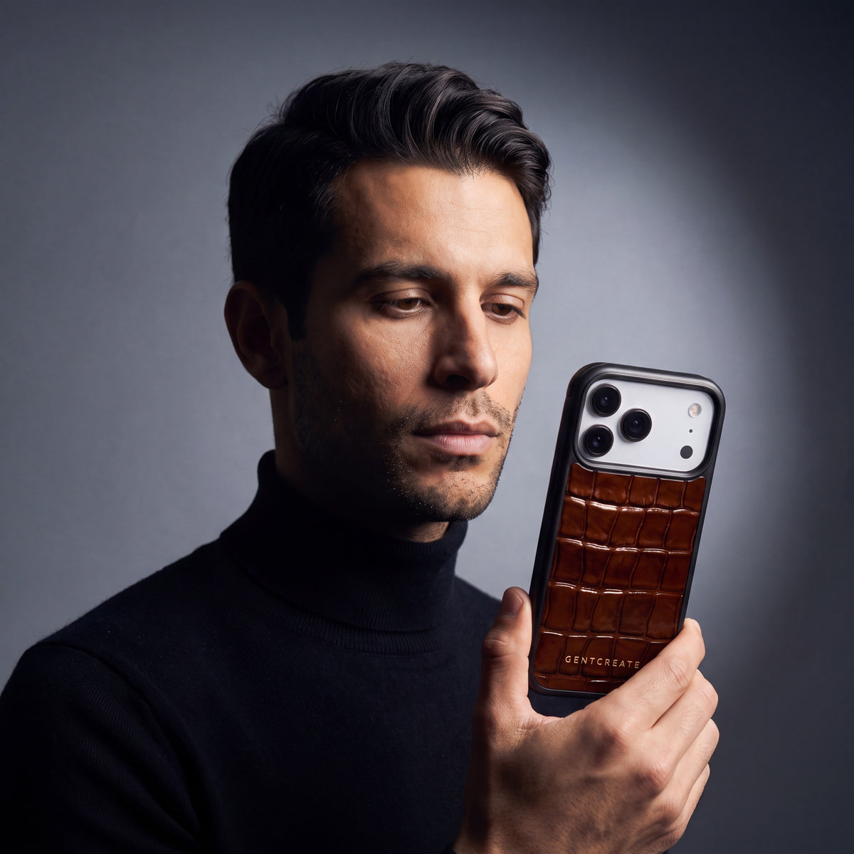Man looking at the brown crocodile-embossed iPhone 18 Pro case by GENTCREATE in his hand