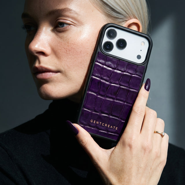 Woman holding a magenta glossy crocodile-embossed calfskin iPhone 18 Pro Max case by GENTCREATE to her cheek