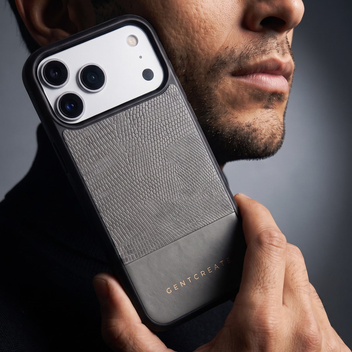 Man holding a gray lizard-embossed leather iPhone 18 Pro Max case by GENTCREATE against his jaw