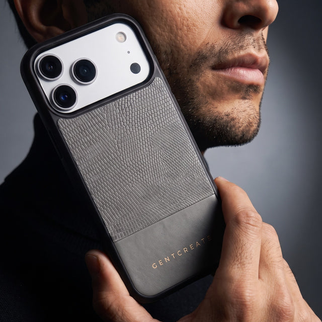 Man holding a gray lizard-embossed leather iPhone 18 Pro Max case by GENTCREATE against his jaw