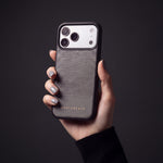 Hand mit taubengrauen Nägeln hält eine graue Hülle aus Kalbsleder mit Eidechsenprägung für iPhone 18 Pro Max von GENTCREATE