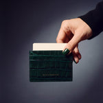 Hand holding a green crocodile-embossed leather card holder by GENTCREATE, a card rising from the top slot