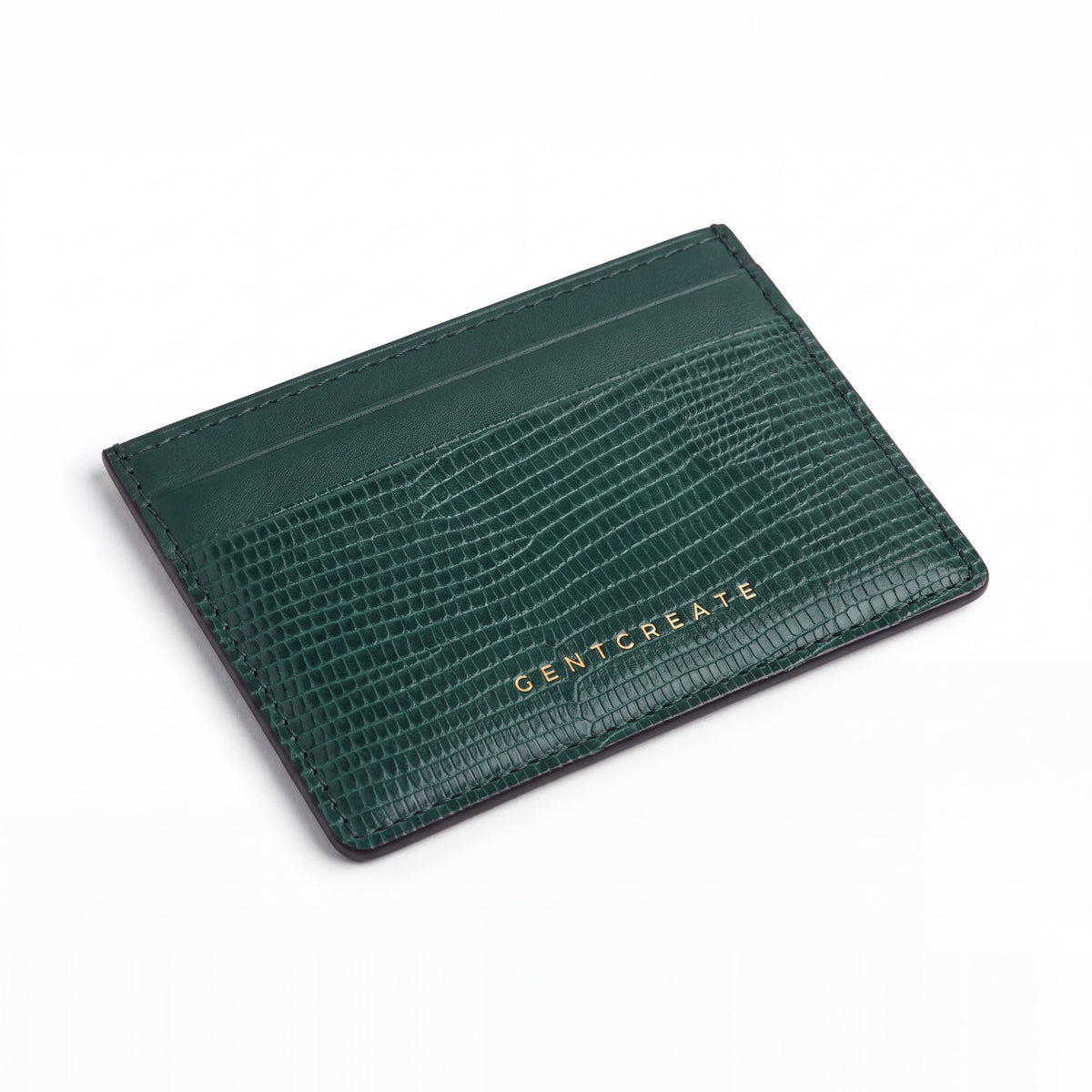 Green lizard-embossed leather business card holder by GENTCREATE lying at an angle on white