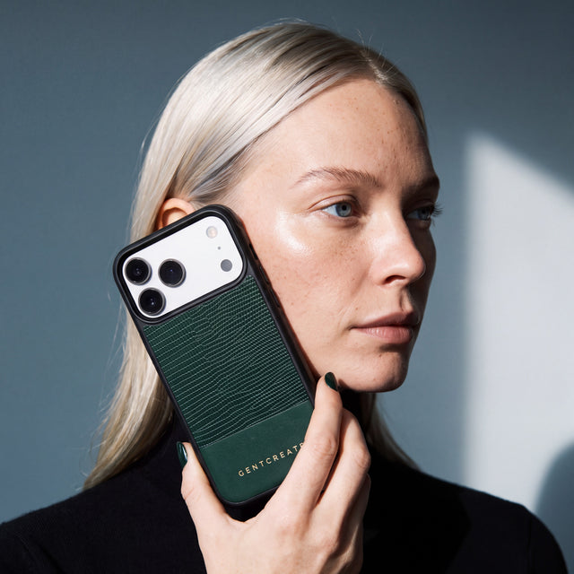 امرأة تمسك جرابًا أخضر لهاتف iPhone 18 Pro Max من جلد عجل بنقش السحلية البارز من GENTCREATE مسندًا إلى خدها تحت ضوء النافذة