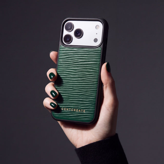 Hånd med grønne negler som holder et grønt iPhone 18 Pro Max-deksel i bølgepreget kalveskinn fra GENTCREATE