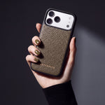 Hand with olive-khaki nails holding a khaki pebble-grain calfskin iPhone 18 Pro Max case by GENTCREATE