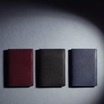 Lizard-embossed leather passport holder by GENTCREATE in burgundy, black and navy, laid flat