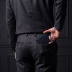Man sliding a navy crocodile-embossed leather bifold wallet by GENTCREATE into his back trouser pocket