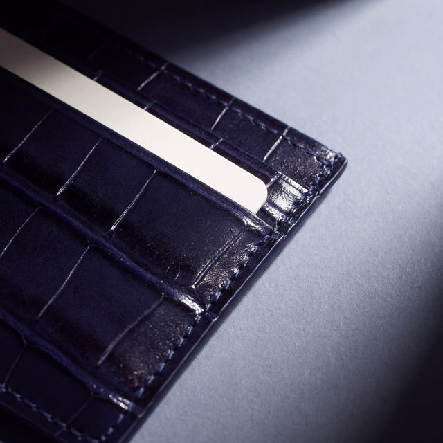 Close-up of the grain and edge of a navy crocodile-embossed leather card holder by GENTCREATE
