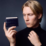 Man holding a slim navy crocodile-embossed leather card holder by GENTCREATE between two fingers