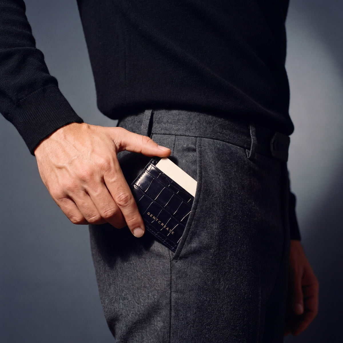 Man sliding a navy crocodile-embossed leather card holder by GENTCREATE into his trouser front pocket