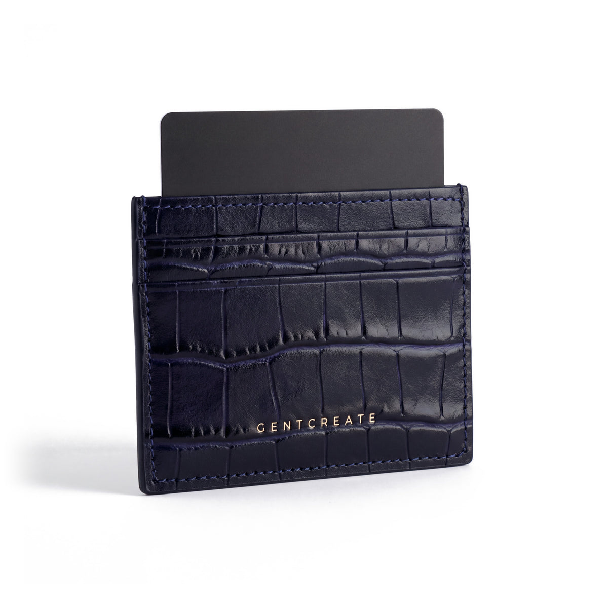 Navy crocodile-embossed leather card holder by GENTCREATE standing with a card, on white