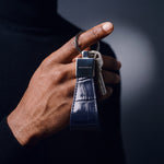 Close-up of a navy crocodile-embossed leather keychain by GENTCREATE with house keys hanging from a finger