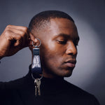 Man holding a navy crocodile-embossed leather keychain by GENTCREATE up beside the face