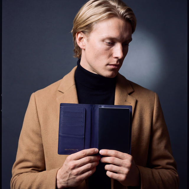 Man opening a navy crocodile-embossed leather passport holder by GENTCREATE with a passport inside