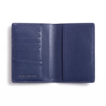 Open navy lizard-embossed leather passport holder by GENTCREATE showing the passport sleeve and card slots, on white