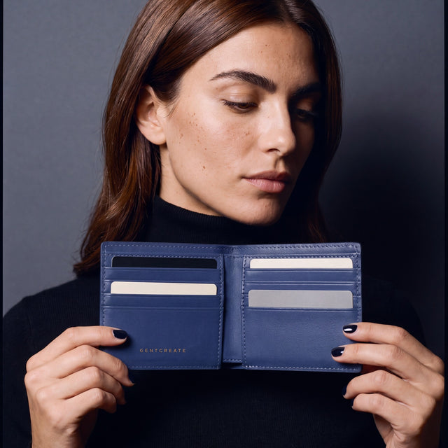 Woman opening a navy lizard leather bifold wallet by GENTCREATE to show the card slots