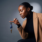 Woman seated with house keys on a navy lizard-embossed leather keychain by GENTCREATE