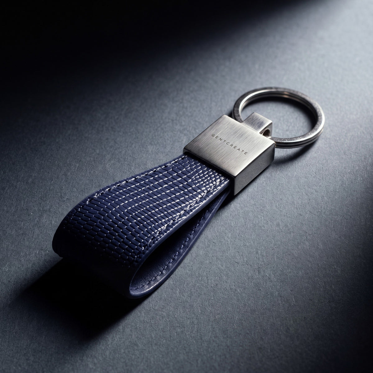 Close-up of the steel clasp of a navy lizard-embossed leather keychain by GENTCREATE