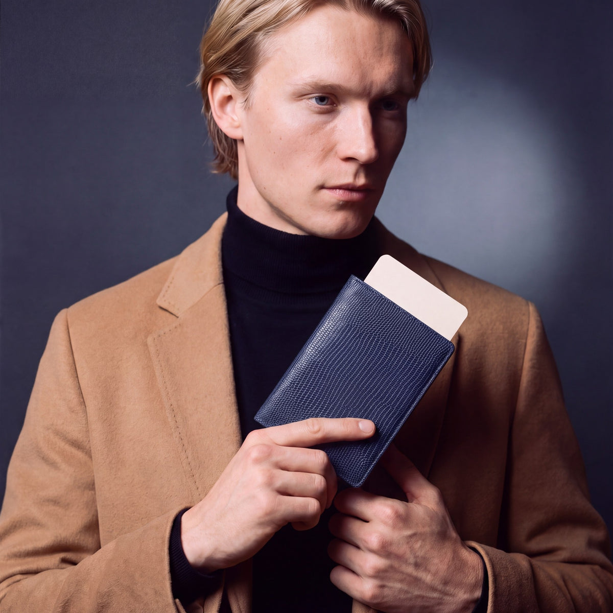 Man holding a navy lizard-embossed leather passport holder by GENTCREATE with a blank card tucked in
