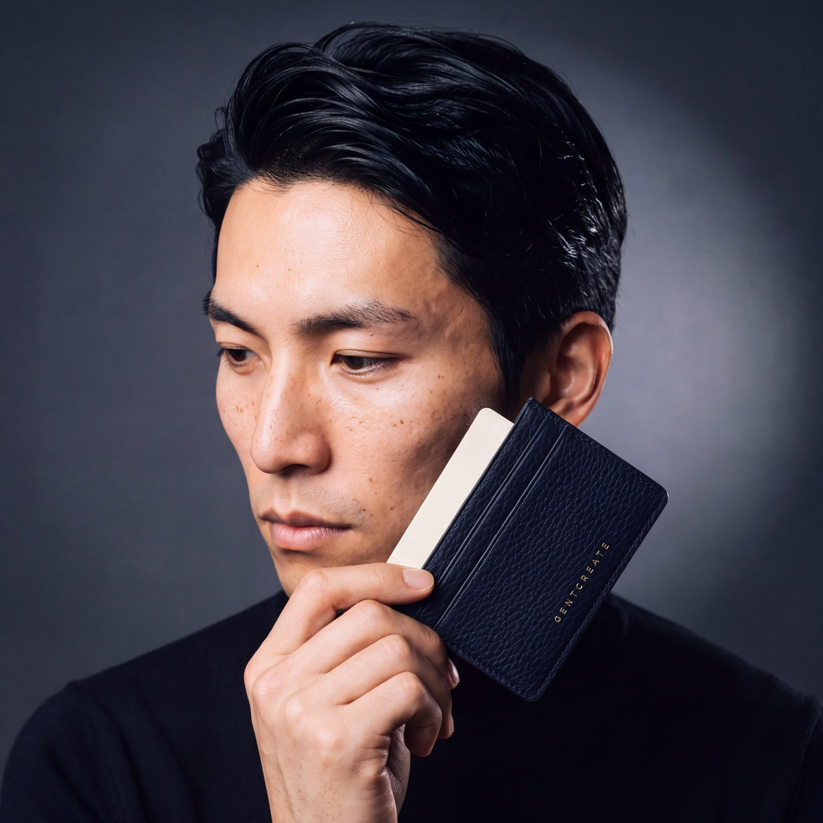 Man holding a slim navy pebble leather card holder by GENTCREATE and drawing out a card